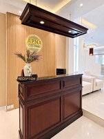 Bancada de recepção com uma placa que diz 'APNA Colombo' e a etiqueta 'RECEPÇÃO'.