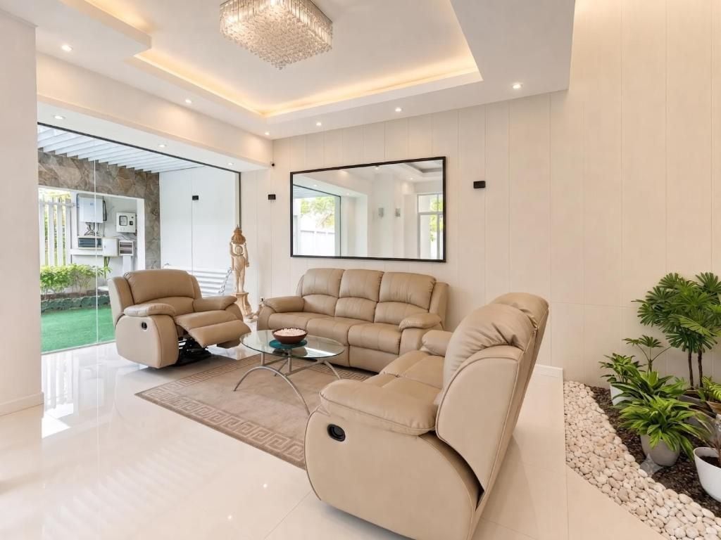 A modern living room with a beige sofa, a recliner, and a glass coffee table.