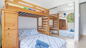 Een slaapkamer met een stapelbed en een spiegel die de kamer weerspiegelt, met uitzicht op de omgeving.