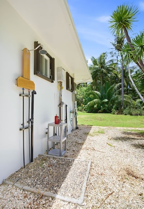 A building with a white exterior, a window with wooden shutters, and a metal structure attached to the wall. -  Private beach with pathway to spacious 3 bedroom home (Hågat)