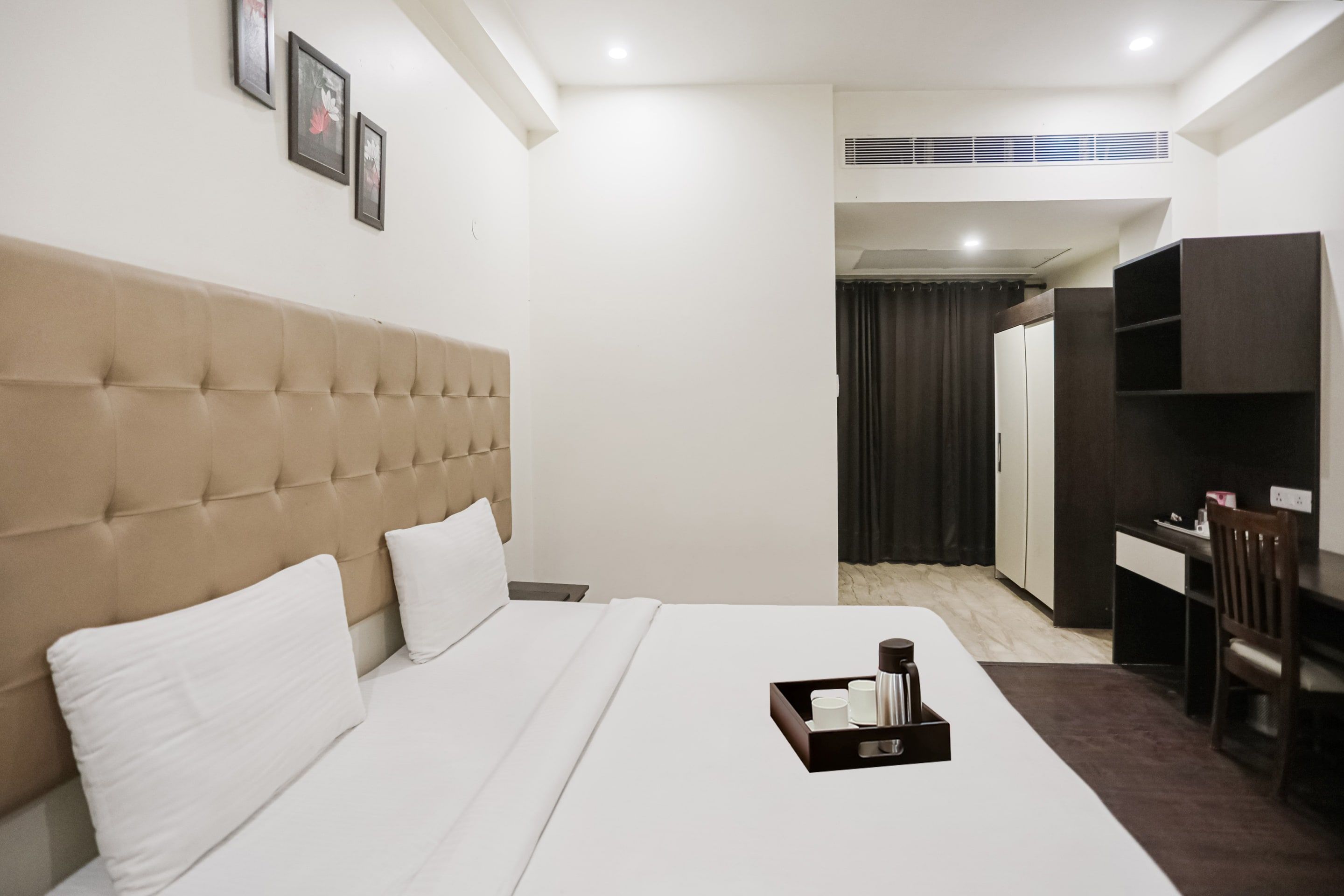 Una habitación de hotel con una cama grande, un escritorio y un armario.