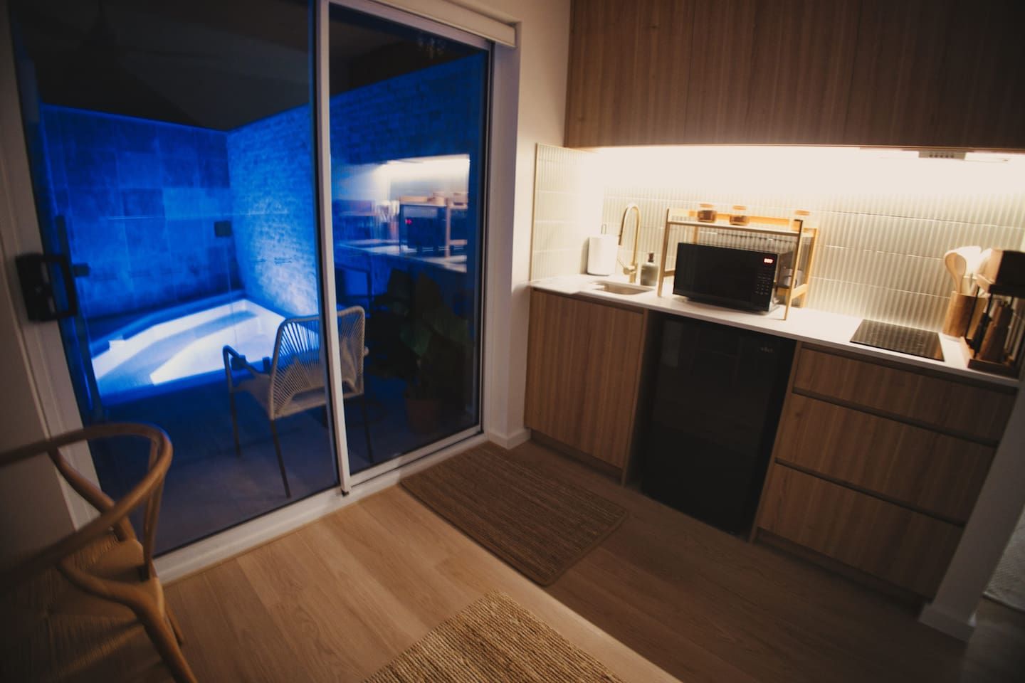 A modern kitchen with a microwave, sink, and wooden cabinets.
