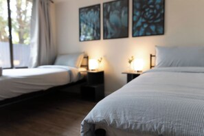 A hotel room with two beds, bedside tables with lamps, and artwork on the wall. - Convenient and Tranquil Retreat in Brisbane South (Shailer Park)