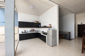 A modern kitchen with a white countertop, black cabinets, and a stainless steel refrigerator. - Hotel O near Hermina Hospital Pekalongan (Pekalongan)