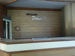 A reception desk with a wooden panel wall displaying the name 'Wisma Datiyah'. - Hotel O near Hasanuddin International Airport formerly Wisma Dalilah Syariah (Makassar)