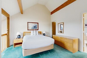 A bedroom with a bed, bedside tables, a dresser, a mirror, and a framed picture on the wall. - 2BR at Nordic Village w/ shared pool, game room near ski, golf & storyland (Bartlett)