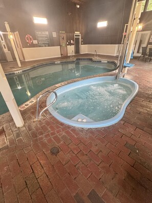 A hot tub area with a pool, a sign indicating spa rules, and a dry sauna. - 2BR at Nordic Village w/ shared pool, game room near ski, golf & storyland (Bartlett)
