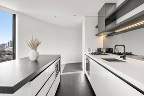 Una cucina moderna con una grande isola, elettrodomestici integrati e vista sulla città.
