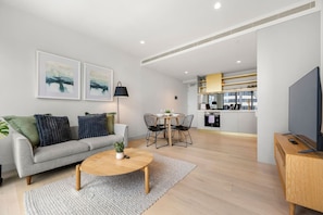 Ein modernes Wohnzimmer mit einer Couch, einem Couchtisch und Kunstwerken an der Wand.