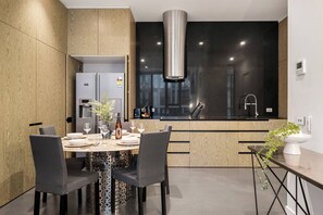 Une cuisine moderne dotée d’un îlot central, d’une cuisinière encastrée et d’une grande fenêtre.