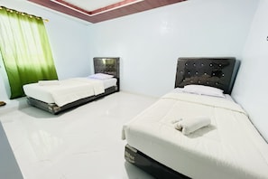 A hotel room with two beds, a green curtain, and a tiled floor.