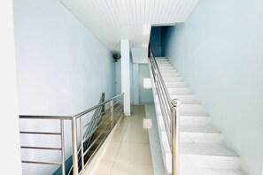 A staircase with metal railings and white steps leading to a landing.