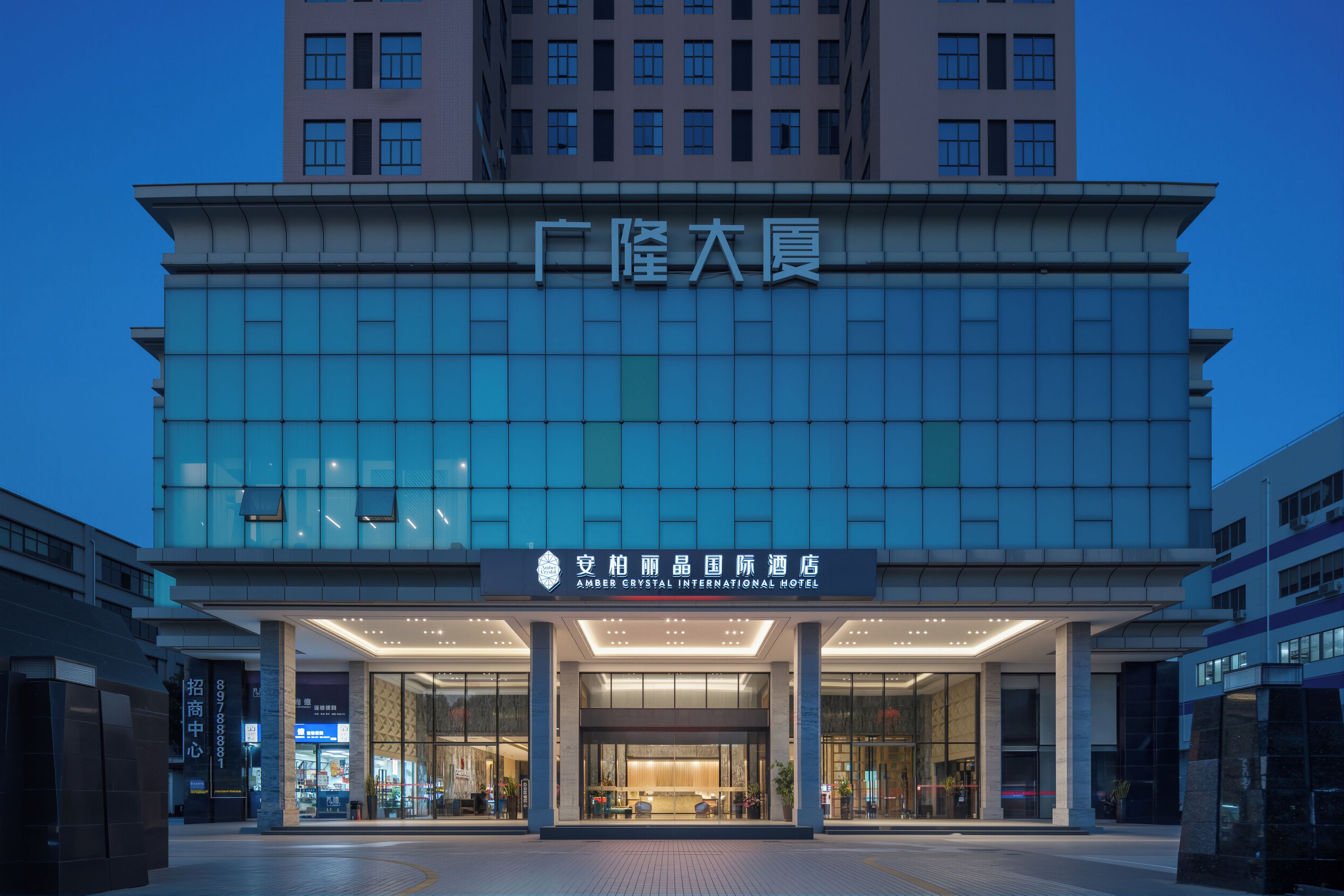 A modern hotel building with a large entrance and a sign indicating it is the Amber Crystal International Hotel.