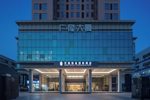 A modern hotel building with a large entrance and a sign indicating it is the Amber Crystal International Hotel. - AMBER CRYSTALINTERNATIONAL HOTEL (Shenzhen)
