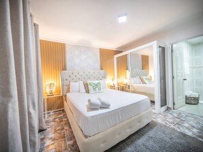 A hotel room with a large bed, a sitting area, a bathroom, and a view of the outside. - Affordable 1BR APT in Sosua Center - Strip Zone (Sosúa)