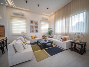 A modern living room with two sofas, a coffee table, and a decorative lamp. - Stylish Luxury Villa in Sosua- 5BR Suites! (Sosúa)