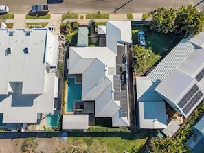 A residential building with multiple roofs, a swimming pool, and a well-maintained garden. - Saltwater Haven - Pool, Beach & Dog-Friendly (Mooloolaba Region)