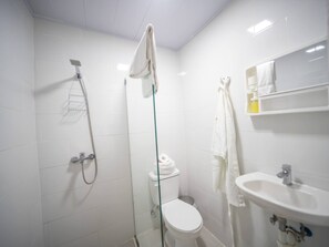 A modern bathroom with a glass-enclosed shower, a toilet, and a sink with a mirror above it. - Room in the center with Outdoor Jacuzzi (Sosúa)