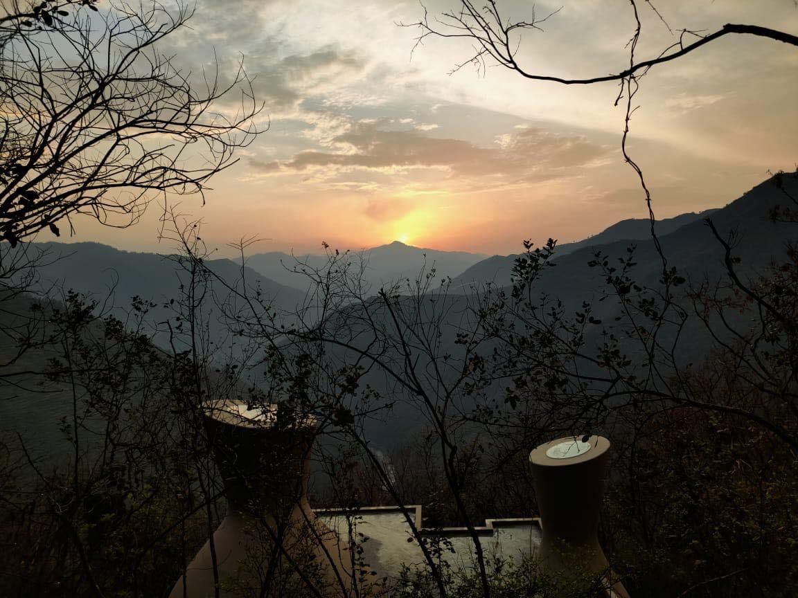 A mountainous landscape with a sunset.