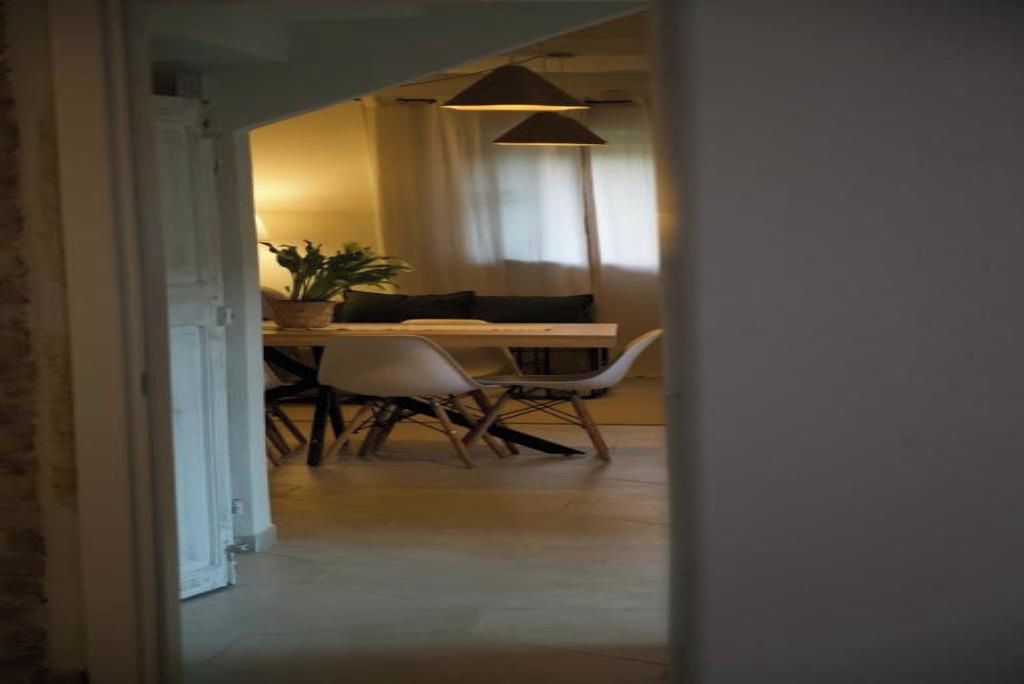 Un espace repas comprenant une table, des chaises et un luminaire suspendu.