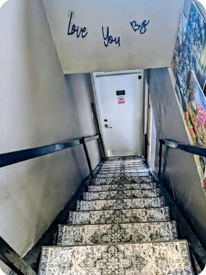 Uma escadaria com uma placa que diz 'Love You 98' acima de uma porta.