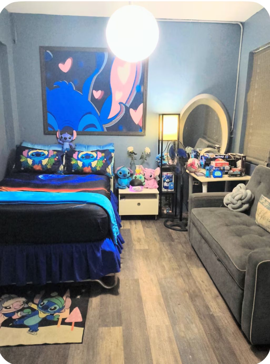 Quarto com cama, sofá, cômoda, espelho e parede com uma pintura grande.