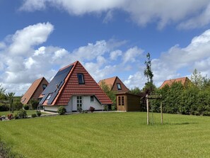 A residential area with multiple houses featuring red-tiled roofs and sloped designs. - Pure sea Breeze (Wurster Nordseeküste)
