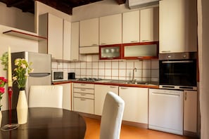 A modern kitchen with white cabinets, a built-in microwave, a gas stove, and a dishwasher. - Casa Brunelleschi by Maison Florence (Florence)