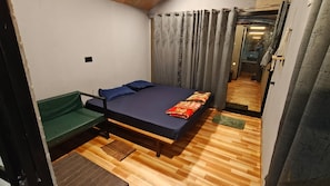 Habitació petita amb un llit, una panxa i una taula.