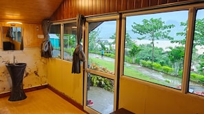 A room with a large window, a sink, and a mirror.