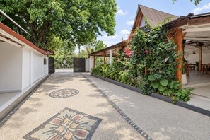 A pathway leading to a covered area with a tiled floor and a patterned design. - Collection O Surya Abadi Guest House  (Tibubeneng)