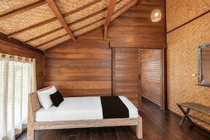 Una habitación de madera con una cama, un banco y un techo tejido.
