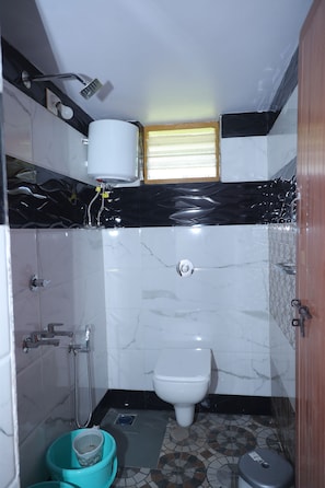 Un baño pequeño con inodoro, ducha y lavamanos.