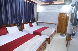 Una habitación de hotel con dos camas, un armario de madera, una televisión y un equipo de aire acondicionado.