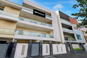 A multi-story building with a sign reading 'OYO TOWNHOUSE'. - Townhouse Hotel Sec- 54 Golf Course Road (Gurugram)
