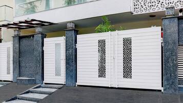 Una entrada protegida con un diseño moderno, que incluye una serie de columnas y detalles de metal decorativo.