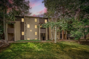 Un edificio de varios pisos con un patio central, rodeado de árboles y un área verde.