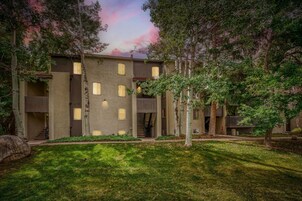 Un edificio de varios pisos con un patio central, rodeado de árboles y un área verde.