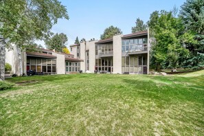 A modern building with a flat roof, large windows, and a well-maintained lawn. - C8 Cornerstone Condos 3 Bedroom Condo (Avon)
