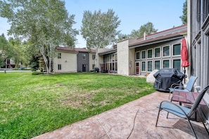 A courtyard with a lawn, outdoor seating, and a building with large windows. - C8 Cornerstone Condos 3 Bedroom Condo (Avon)