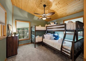 A bunk bed room with a ceiling fan, a desk with a plant, and a window with blinds. - Lakefront w/ Private Shoreline | Kayaks + Paddle Boards + Firepit | Covewood (Lakeville)