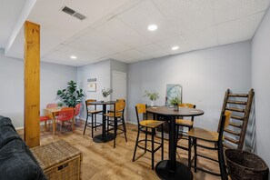 Un comedor con una mesa redonda, sillas y una pared de acento de madera.