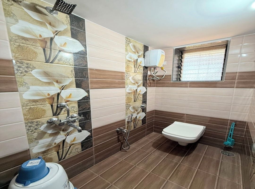 A bathroom with a toilet, bidet, and a window.
