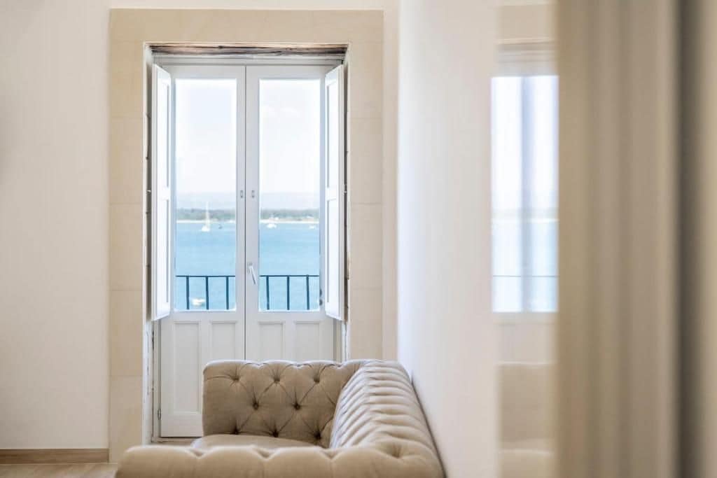 Una habitación con un ventanal grande, una puerta y un sofá.