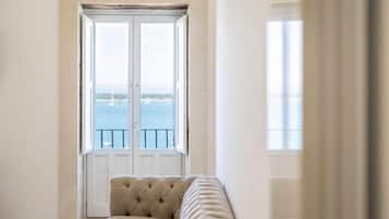 Una habitación con un ventanal grande, una puerta y un sofá.