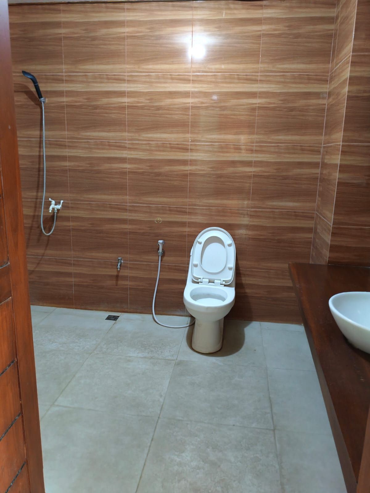 A bathroom with a toilet, a shower, and a sink.