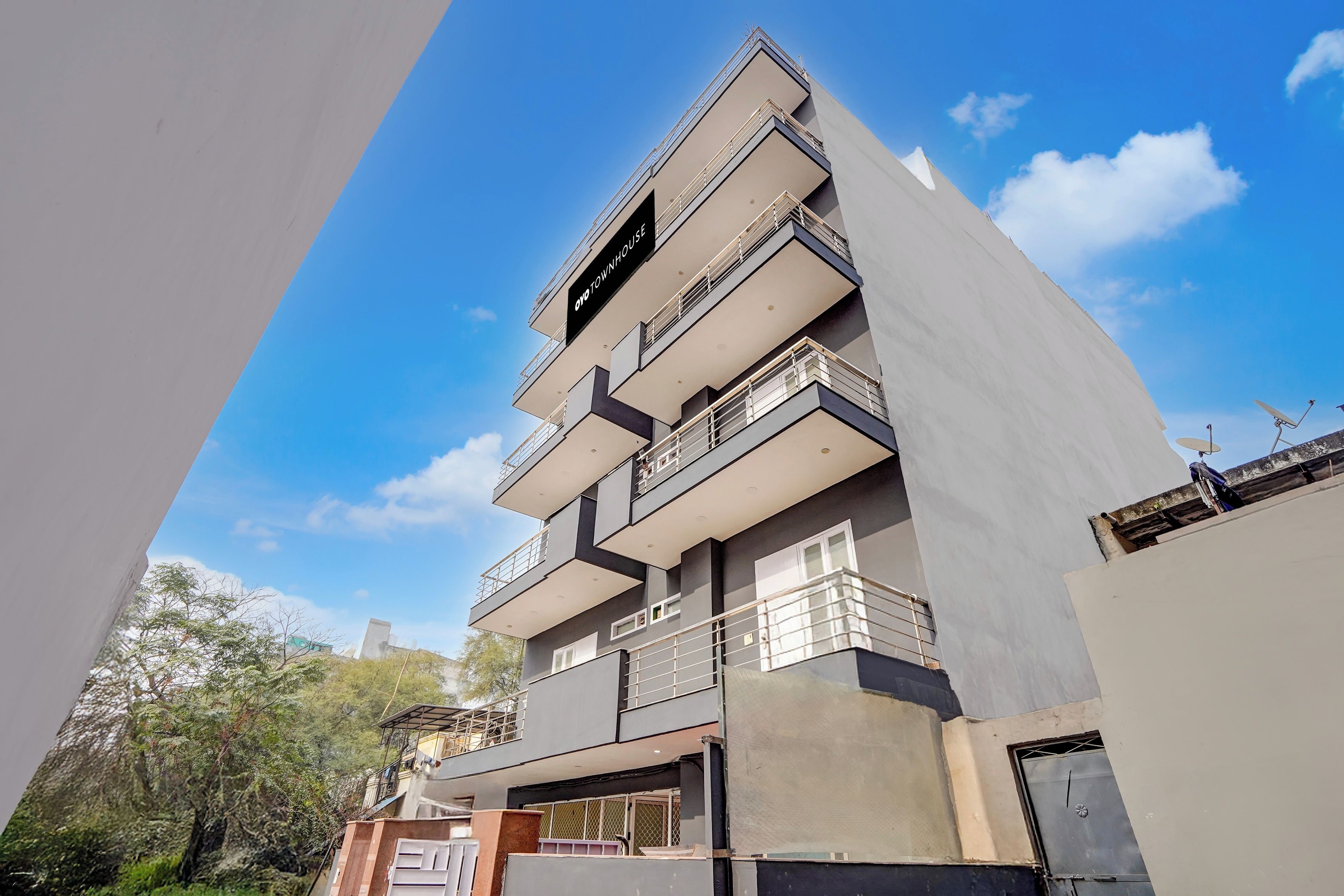 A multi-story residential building with balconies and a clear sky.
