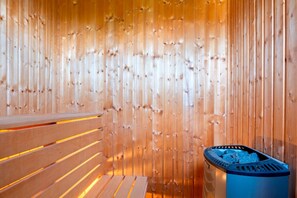 A sauna with wooden benches and a metal heater. - Charming Bro Retreat, Luxury Comfort & Modern Amenities (Bro)