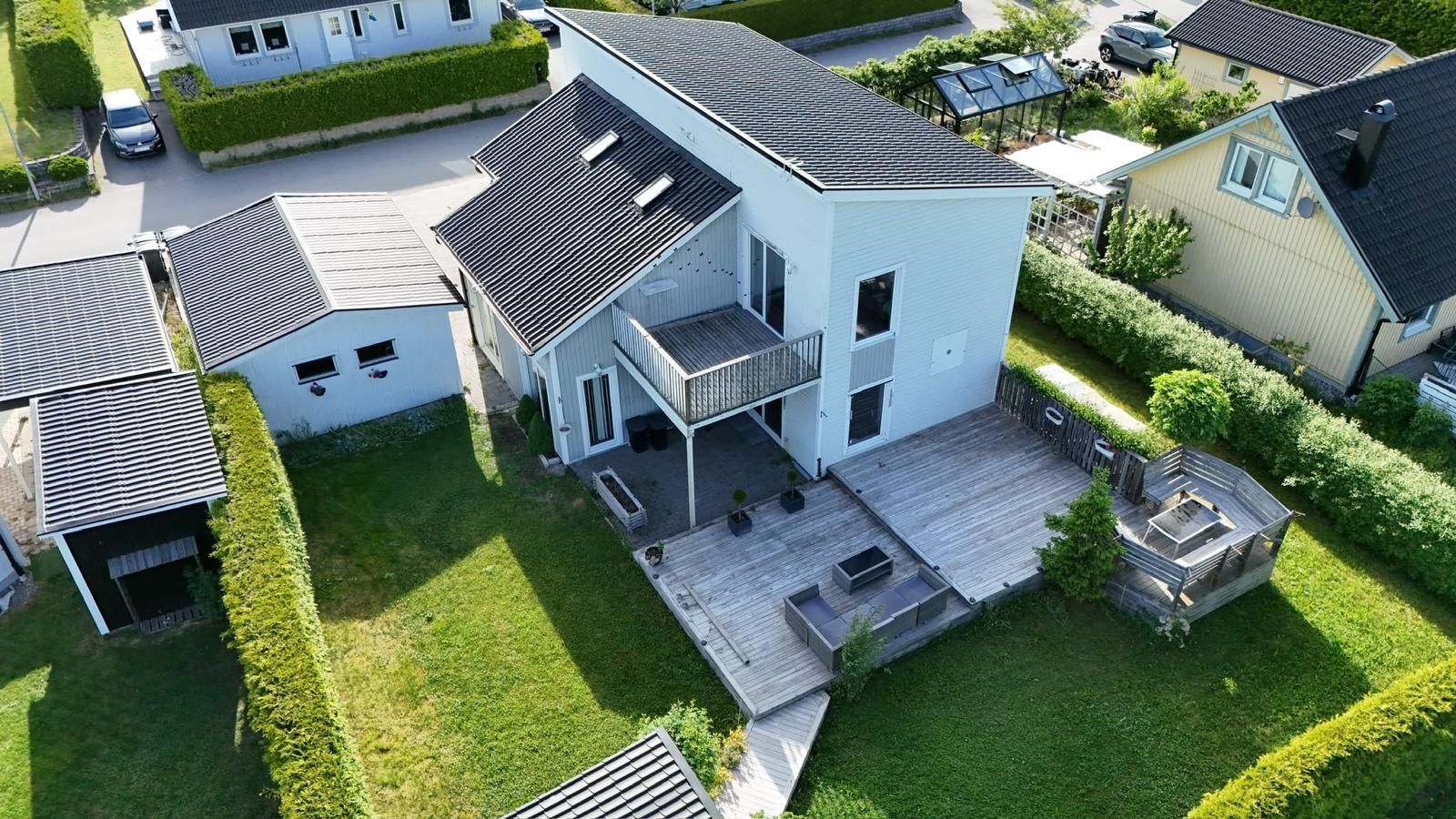 A two-story house with a balcony, a deck, and a fenced yard.