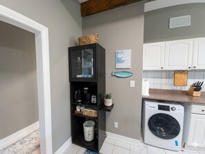 A compact kitchen with a built-in washer, a coffee maker, and a fish decoration on the wall. - Waterfront Autumn getaway with private dome (Whitchurch-Stouffville)